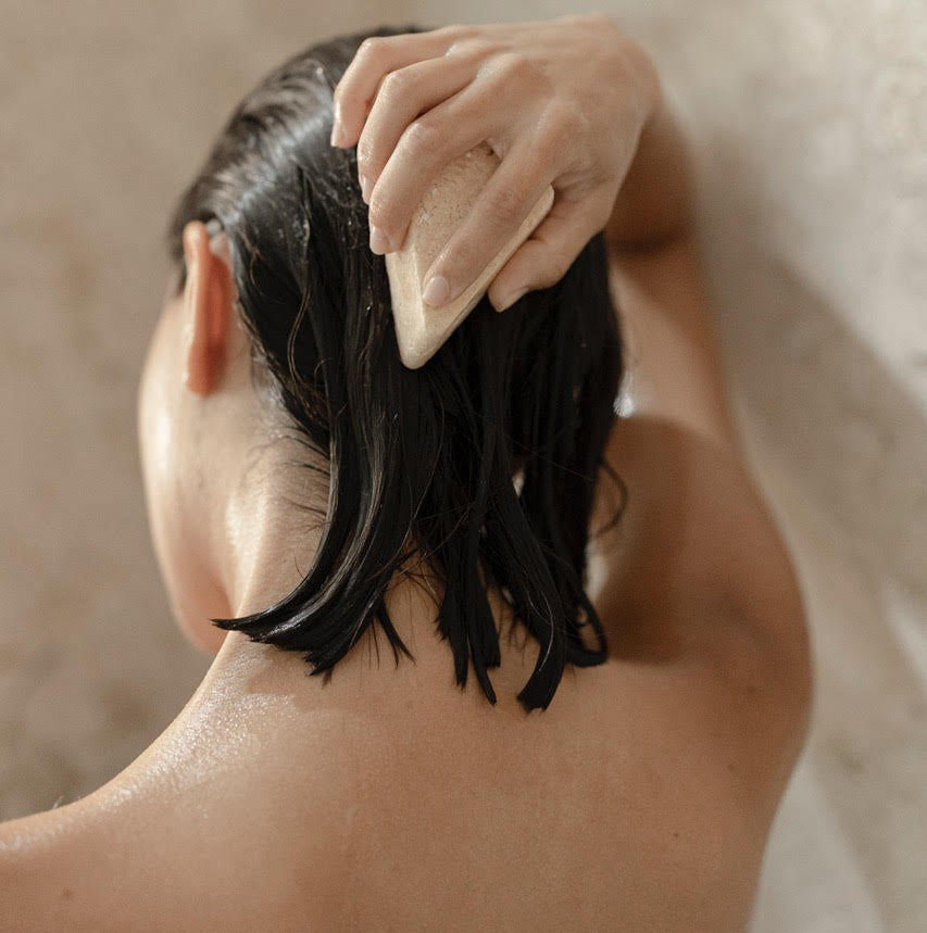 Mujer lavándose el cabello con shampoo en barra