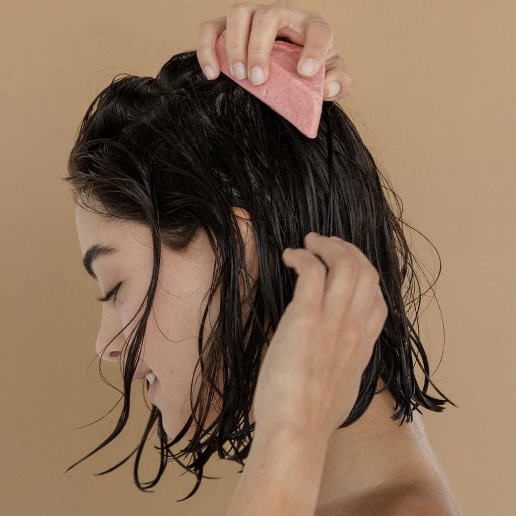 mujer lavándose el cabello con shampoo para rizos ondas